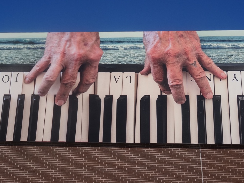 Mural of hands playing a piano called "Playing La Jolla For Keeps"